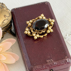 Vintage gold‑tone Victorian Revival brooch with red faceted glass cabochon and faux pearls.