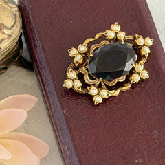 Vintage gold‑tone Victorian Revival brooch with red faceted glass cabochon and faux pearls.