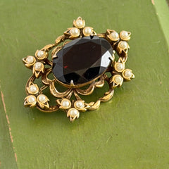 Vintage gold‑tone Victorian Revival brooch with red faceted glass cabochon and faux pearls.