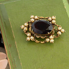 Vintage gold‑tone Victorian Revival brooch with red faceted glass cabochon and faux pearls.