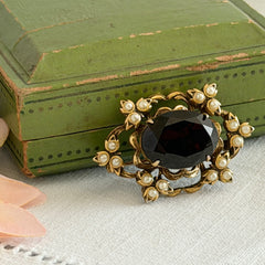 Vintage gold‑tone Victorian Revival brooch with red faceted glass cabochon and faux pearls.
