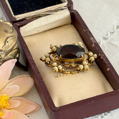 Vintage gold‑tone Victorian Revival brooch with red faceted glass cabochon and faux pearls.