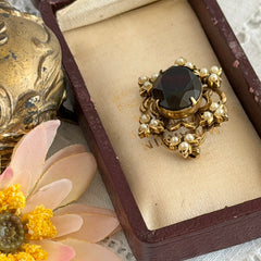 Vintage gold‑tone Victorian Revival brooch with red faceted glass cabochon and faux pearls.