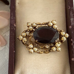 Vintage gold‑tone Victorian Revival brooch with red faceted glass cabochon and faux pearls.