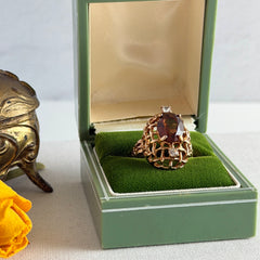 Vintage gold plated ring with an oval dark‑topaz CZ center stone and two clear rhinestone accents.