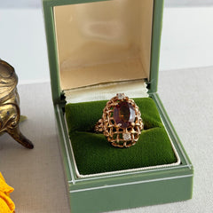 Vintage gold plated ring with an oval dark‑topaz CZ center stone and two clear rhinestone accents.
