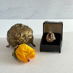 Vintage gold plated ring with an oval dark‑topaz CZ center stone and two clear rhinestone accents.