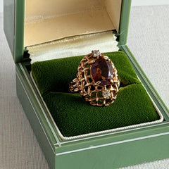 Vintage gold plated ring with an oval dark‑topaz CZ center stone and two clear rhinestone accents.
