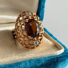 Vintage gold plated ring with an oval dark‑topaz CZ center stone and two clear rhinestone accents.