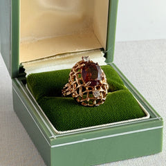 Vintage gold plated ring with an oval dark‑topaz CZ center stone and two clear rhinestone accents.