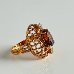 Vintage gold plated ring with an oval dark‑topaz CZ center stone and two clear rhinestone accents.