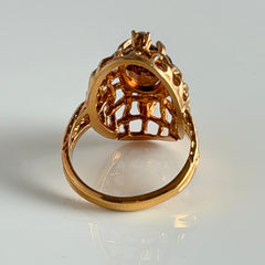 Vintage gold plated ring with an oval dark‑topaz CZ center stone and two clear rhinestone accents.