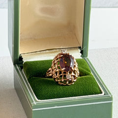 Vintage gold plated ring with an oval dark‑topaz CZ center stone and two clear rhinestone accents.