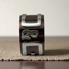 Dolce & Gabbana men's stainless steel ring with brown finish and raised silver-tone logo; bold designer accessory in size 8.5 with wide band styling.