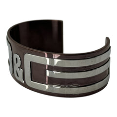 Dolce & Gabbana men's stainless steel cuff bracelet with a brown finish and raised silver-tone logo plaque; modern designer accessory with bold branding and sculptural detail.