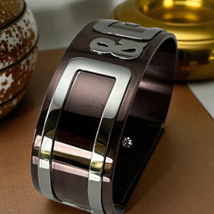 Dolce & Gabbana men's stainless steel cuff bracelet with a brown finish and raised silver-tone logo plaque; modern designer accessory with bold branding and sculptural detail.