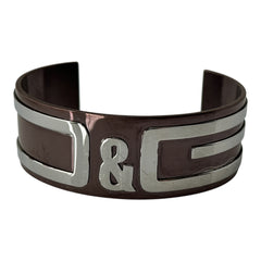 Dolce & Gabbana men's stainless steel cuff bracelet with a brown finish and raised silver-tone logo plaque; modern designer accessory with bold branding and sculptural detail.