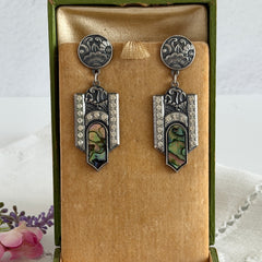 Vintage Duri Art Deco‑style abalone and rhinestone dangle post earrings with ornate floral metalwork and iridescent inlay, shown on display and vintage box.
