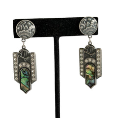 Vintage Duri Art Deco‑style abalone and rhinestone dangle post earrings with ornate floral metalwork and iridescent inlay, shown on display and vintage box.