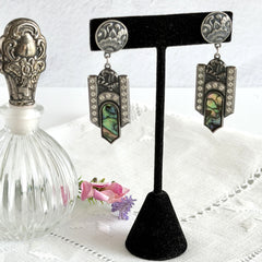 Vintage Duri Art Deco‑style abalone and rhinestone dangle post earrings with ornate floral metalwork and iridescent inlay, shown on display and vintage box.