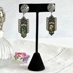 Vintage Duri Art Deco‑style abalone and rhinestone dangle post earrings with ornate floral metalwork and iridescent inlay, shown on display and vintage box.