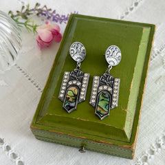 Vintage Duri Art Deco‑style abalone and rhinestone dangle post earrings with ornate floral metalwork and iridescent inlay, shown on display and vintage box.
