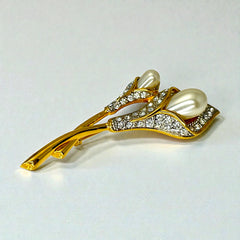 Vintage Edith Vanderbilt gold‑tone arum flowers brooch featuring two sculptural blooms with faux pearls and clear pave rhinestones, shown in various styled settings to highlight its elegant curves and luminous detail.