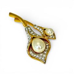 Vintage Edith Vanderbilt gold‑tone arum flowers brooch featuring two sculptural blooms with faux pearls and clear pave rhinestones, shown in various styled settings to highlight its elegant curves and luminous detail.