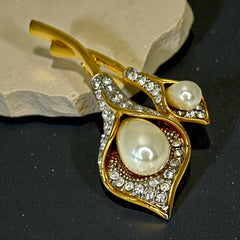 Vintage Edith Vanderbilt gold‑tone arum flowers brooch featuring two sculptural blooms with faux pearls and clear pave rhinestones, shown in various styled settings to highlight its elegant curves and luminous detail.