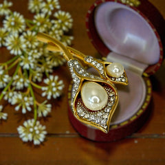 Vintage Edith Vanderbilt gold‑tone arum flowers brooch featuring two sculptural blooms with faux pearls and clear pave rhinestones, shown in various styled settings to highlight its elegant curves and luminous detail.