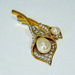 Vintage Edith Vanderbilt gold‑tone arum flowers brooch featuring two sculptural blooms with faux pearls and clear pave rhinestones, shown in various styled settings to highlight its elegant curves and luminous detail.