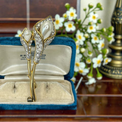 Vintage Edith Vanderbilt gold‑tone arum flowers brooch featuring two sculptural blooms with faux pearls and clear pave rhinestones, shown in various styled settings to highlight its elegant curves and luminous detail.
