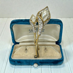 Vintage Edith Vanderbilt gold‑tone arum flowers brooch featuring two sculptural blooms with faux pearls and clear pave rhinestones, shown in various styled settings to highlight its elegant curves and luminous detail.