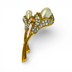 Vintage Edith Vanderbilt gold‑tone arum flowers brooch featuring two sculptural blooms with faux pearls and clear pave rhinestones, shown in various styled settings to highlight its elegant curves and luminous detail.