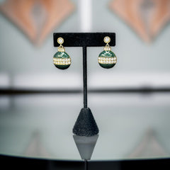 Vintage Eisenberg Ice Christmas ornament earrings with green enamel, clear rhinestone band, and gold-tone stud; signed and festive dangle design.