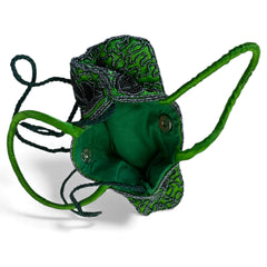 Vintage 1990s emerald green satin evening bag with handsewn black and hematite glass bead floral motifs, dual green handles, and optional crossbody cord, photographed to show craftsmanship, texture, and convertible styling.