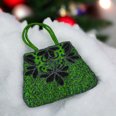 Vintage 1990s emerald green satin evening bag with handsewn black and hematite glass bead floral motifs, dual green handles, and optional crossbody cord, photographed to show craftsmanship, texture, and convertible styling.