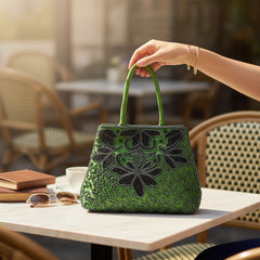 Vintage 1990s emerald green satin evening bag with handsewn black and hematite glass bead floral motifs, dual green handles, and optional crossbody cord, photographed to show craftsmanship, texture, and convertible styling.