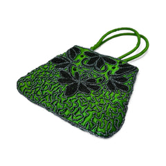 Vintage 1990s emerald green satin evening bag with handsewn black and hematite glass bead floral motifs, dual green handles, and optional crossbody cord, photographed to show craftsmanship, texture, and convertible styling.