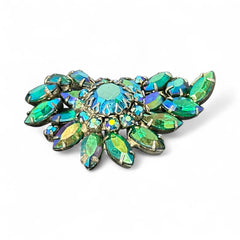 Vintage 1950s brooch featuring layered AB emerald rhinestones in marquise and chaton cuts, set in silver tone metal with a central dog tooth prong setting; photographed to highlight sparkle, craftsmanship, and mid-century design.