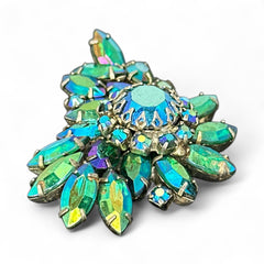 Vintage 1950s brooch featuring layered AB emerald rhinestones in marquise and chaton cuts, set in silver tone metal with a central dog tooth prong setting; photographed to highlight sparkle, craftsmanship, and mid-century design.