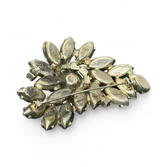 Vintage 1950s brooch featuring layered AB emerald rhinestones in marquise and chaton cuts, set in silver tone metal with a central dog tooth prong setting; photographed to highlight sparkle, craftsmanship, and mid-century design.