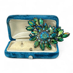 Vintage 1950s brooch featuring layered AB emerald rhinestones in marquise and chaton cuts, set in silver tone metal with a central dog tooth prong setting; photographed to highlight sparkle, craftsmanship, and mid-century design.