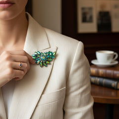 Vintage 1950s brooch featuring layered AB emerald rhinestones in marquise and chaton cuts, set in silver tone metal with a central dog tooth prong setting; photographed to highlight sparkle, craftsmanship, and mid-century design.