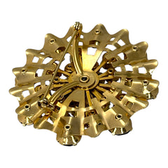 Vintage 1950s gold tone brooch with a ruffled sunburst design, featuring concentric rings of emerald and peridot rhinestones and a large green center stone; bold mid-century costume jewelry with layered sparkle and sculptural detail.