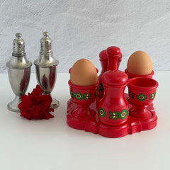 Vintage Emsa West Germany red plastic kitchen set with green flower pattern, featuring salt and pepper shakers, egg cups, and tray.