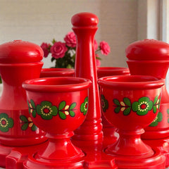 Vintage Emsa West Germany red plastic kitchen set with green flower pattern, featuring salt and pepper shakers, egg cups, and tray.