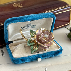 Vintage 1997 Graziano ‘England’s Rose’ brooch with light pink enamel‑painted petals, light green enamel‑painted leaves, clear rhinestones, and a gold‑tone stem, signed on the back.