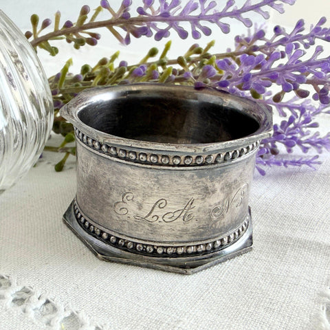 Antique silver‑plated napkin ring with beaded borders and engraved E.L.A. No. 3.