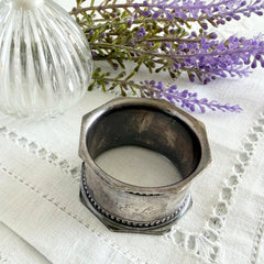 Antique silver‑plated napkin ring with beaded borders and engraved E.L.A. No. 3.